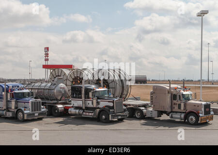 An American Peterbilt 379 semi truck hauling reels of HDPE plastic pipe on a flatbed trailer for the oil industry and fracking sites in the USA Stock Photo