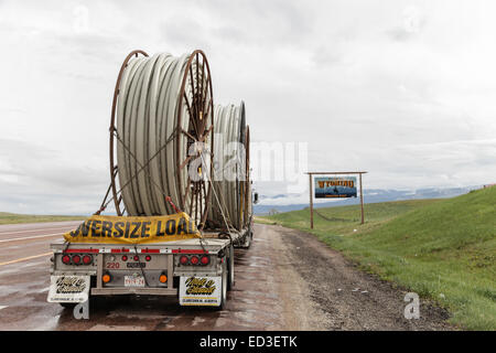 An American Peterbilt 379 semi truck hauling reels of HDPE plastic pipe on a flatbed trailer for the oil industry and fracking sites in the USA Stock Photo