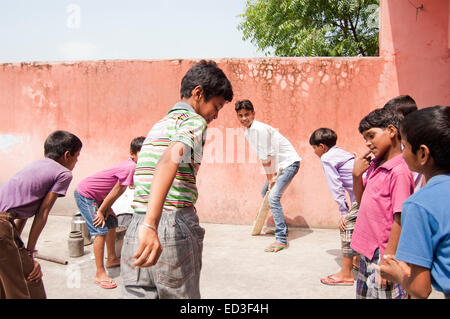 indian rural group children boys Playing cricket Stock Photo