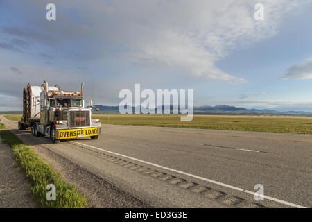 Reels of plastic underground pipe on a Peterbilt 379  flatdeck trailer heading for the US oilfields from Calgary Canada Stock Photo