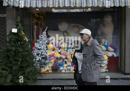 Tehran, Iran. 25th Dec, 2014. December 25, 2014 - Tehran, Iran - An Iranian couple walk past a shop window decorated for the Christian New Year shopping in Tehran's business district. Morteza Nikoubazl/ZUMAPRESS Credit:  Morteza Nikoubazl/ZUMA Wire/Alamy Live News Stock Photo