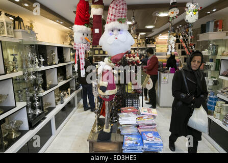 Tehran, Iran. 25th Dec, 2014. December 25, 2014 - Tehran, Iran - An Iranian woman walks at a shop which is decorated for the Christian New Year shopping in Tehran's business district. Morteza Nikoubazl/ZUMAPRESS Credit:  Morteza Nikoubazl/ZUMA Wire/Alamy Live News Stock Photo