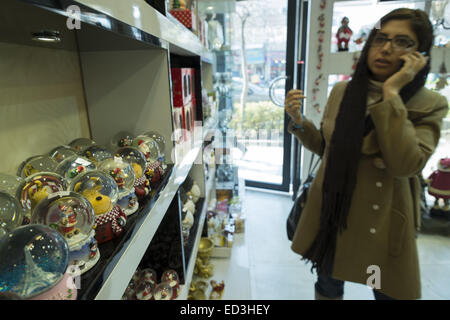 Tehran, Iran. 25th Dec, 2014. December 25, 2014 - Tehran, Iran - An Iranian-Christian woman speaks on her smartphone while shopping during the Christian New Year shopping in Tehran's business district. Morteza Nikoubazl/ZUMAPRESS Credit:  Morteza Nikoubazl/ZUMA Wire/Alamy Live News Stock Photo