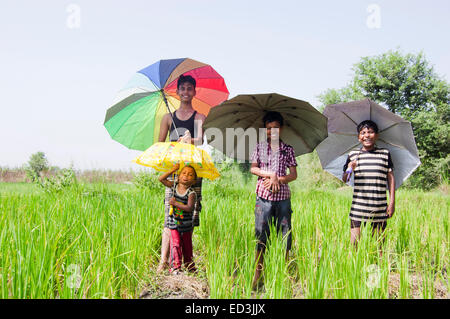 indian rural children boys holding Umbrella rain season enjoy Stock Photo