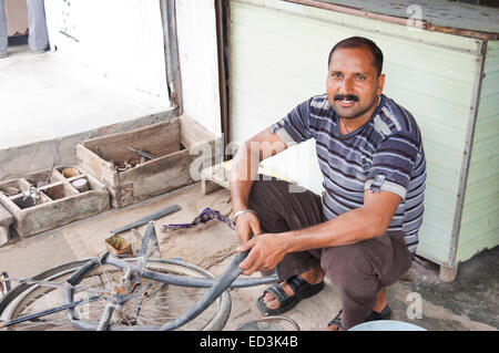 1 indian rural man Cycle Tyre Mechanic Stock Photo