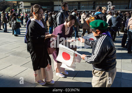 Thousands of Japanese people, including right-wing nationalists, come every year to greet their Emperor on the day of his birthday. Emperor Akihito, accompanied by Empress Michiko and all the members of his family, appears several times in a large window of the Imperial Palace to give his speech. While other people greeted the Emperor silently by waving little Japanese flags, nationalists sang the national anthem and screemed 'Banzai' to demonstrate their affilitation. © Martin Hladik/AFLO/Alamy Live News Stock Photo