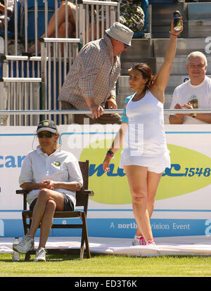 Marion Bartoli cheekily asks a fan if she can have a one of his cans of cider for her tennis partner, former player and Sky pundit Barry Cowan, during their doubles match at the Liverpool Hope University International Tennis Tournament. While Cowan supped Stock Photo