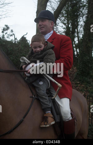 25th December 2014. Oakham, Rutland, England. A young boy  in the saddle with the huntsman, Andrew Osborne MFH., at the traditional Cottesmore Hunt Boxing Day Meet held in Cutts Close, Oakham, Rutland, England Credit:  Jim Harrison/Alamy Live News Stock Photo