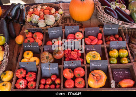 Mixed tomato varieties on display in pigeon hole boxes with other seasonal fruit and vegetables Stock Photo