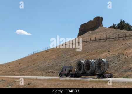 An American semi truck hauling reels of HDPE plastic pipe on a flatbed trailer for the oil industry and fracking sites in the USA Stock Photo