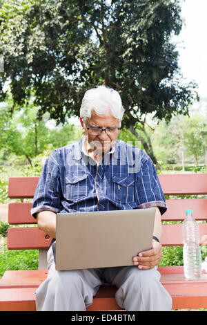 indian Old man park laptop working Stock Photo