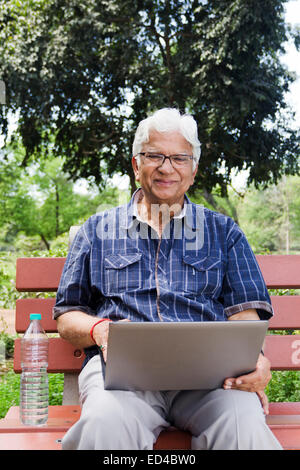 indian Old man park laptop working Stock Photo