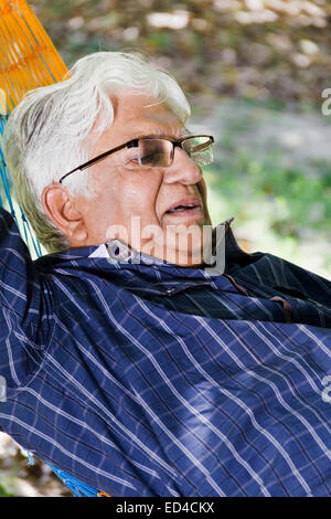 indian Old man park resting  Hammock Stock Photo