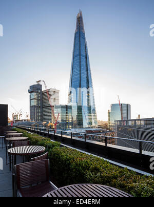 Shard of Glass building towering over other buildings on south side of Thames at dusk in London, England, UK Stock Photo