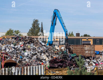 Scrap metal junk yard in Nuremburg Germany with a crane and large grab jaws working the metal Stock Photo