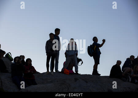 Tourists at dusk on Glacier Point above Yosemite Valley, California, USA. Stock Photo