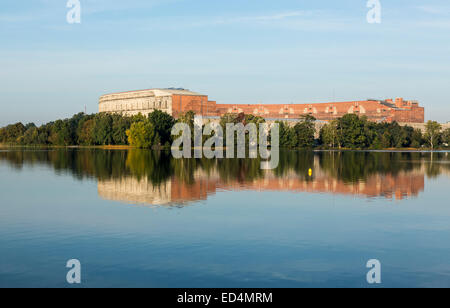 The remains of the large Congress Hall or Kongresshalle at the Nazi Parade grounds and reflected in still lake in Nuremberg, Ger Stock Photo