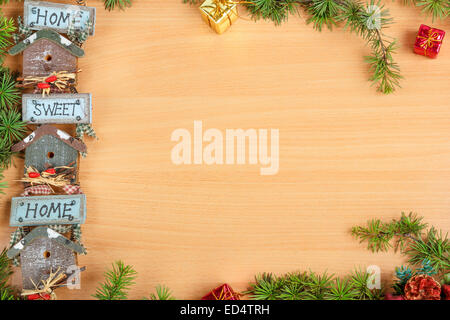 Christmas decoration with fir tree and gift with a motif or motive home sweet home in shaped snow house with message on wooden b Stock Photo