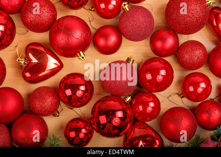 Wonderful Christmas decoration with lots of beautiful red ornaments scattered on wooden light brown surface Stock Photo