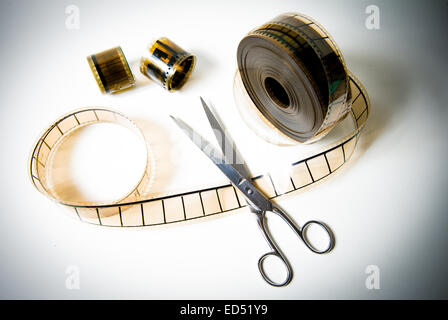 A 35mm movie film reel cutted with scissors on white background and color effect Stock Photo