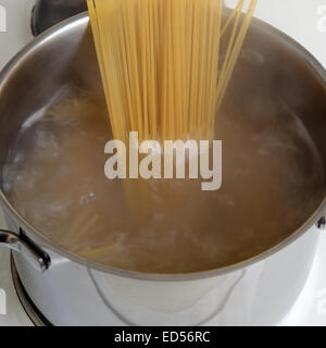 Preparing spaghetti pasta food meal cooking noodles in water in pot Stock Photo