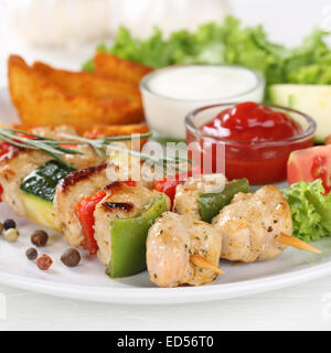 Chicken meat skewers meal with potatoes and vegetables on a plate Stock Photo