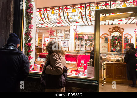 Brussels, Belgium, People Enjoying Christmas Lights, Local Chocolate, Shop Front Window in old Commercial Shopping Mall, in City Center, Small Shop Night Stock Photo