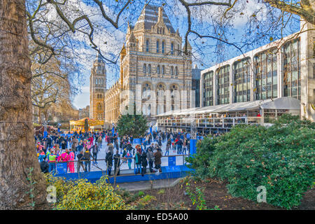 LONDON NATURAL HISTORY MUSEUM AND ICE SKATERS ON THE RINK AT CHRISTMAS TIME Stock Photo