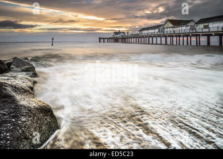 Sunrise on Southwold Peir, showing the waves breaking on the beach infront Stock Photo