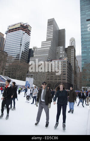 People enjoy the holiday season ice skating at Bryant Park in midtown Manhattan, NYC. Stock Photo