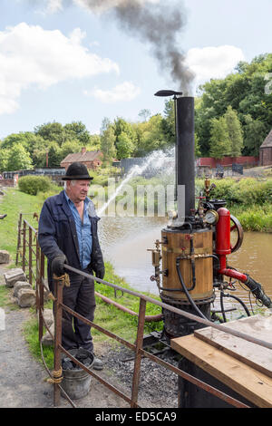 Man with steam powered pump, Blists Hill Victorian town, Ironbridge, Shropshire, England, UK Stock Photo