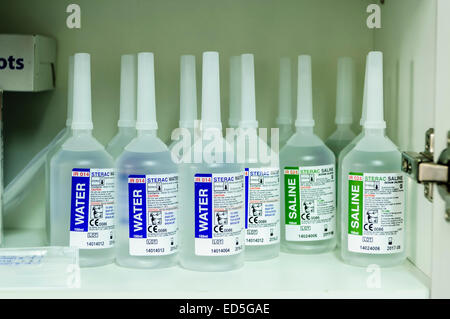 Bottles of water and saline in the cupboard of a hospital clinical room Stock Photo