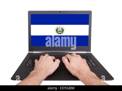 Hands working on laptop showing on the screen the flag of El Salvador Stock Photo
