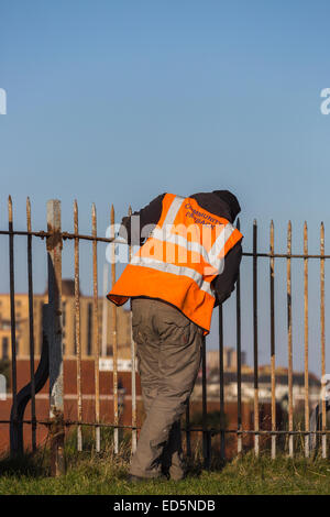 Offender working at Southsea Castle, Portsmouth, carrying out community service; orange jacket inscribed 'Community Payback' Stock Photo