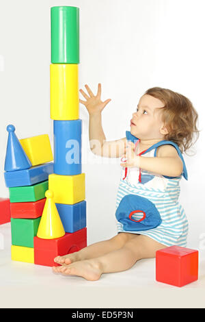 A little girl builds a house. Stock Photo