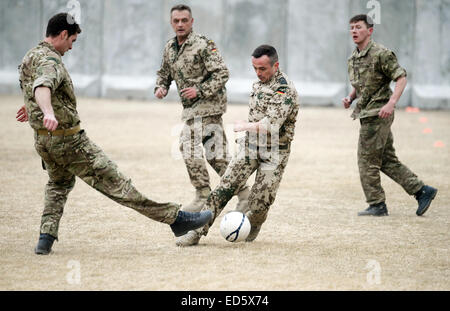 Kabul, Afghanistan. 24th Dec, 2014. British and German soldiers fight for the ball during a soccer match on the remodeled heliport of the ISAF headquarters in Kabul, Afghanistan, 24 December 2014. On the occasion of the 100th anniversary of the 'Christmas truce', when German, British and French soldiers laid down their arms in the trenches of Flanders in 1914 to play some soccer, the German and British soldiers in Kabul initiated the match. Photo: Subel Bhandari/dpa/Alamy Live News Stock Photo
