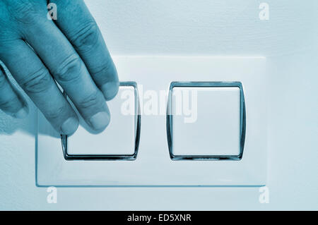 a man pressing a wall switch Stock Photo