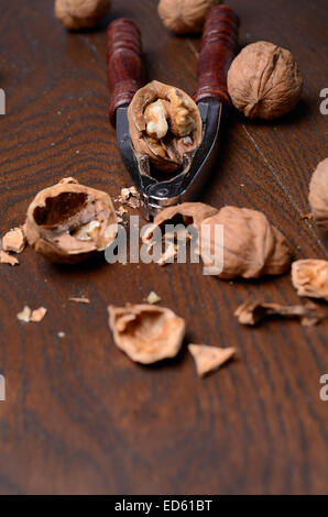 Walnuts with a nutcracker on a wooden table Stock Photo