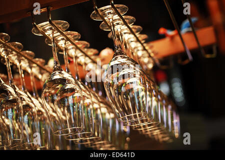 Many empty glasses for a wine hanging in the bar. Close up photo with selective focus Stock Photo