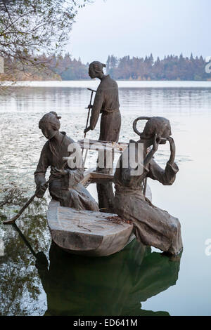 Hangzhou, China - December 4, 2014: Chinese outdoor sculpture with boatman and passengers on traditional small boat. West Lake Stock Photo