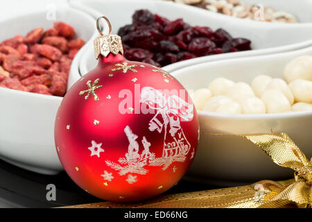 Red christmas bal with chocolate nuts in background Stock Photo