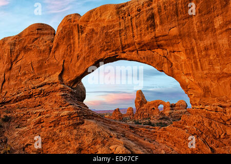 Turret Arch seen through North Window at first light in Utah’s Arches National Park. Stock Photo