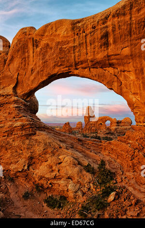 Turret Arch seen through North Window at first light in Utah’s Arches National Park. Stock Photo
