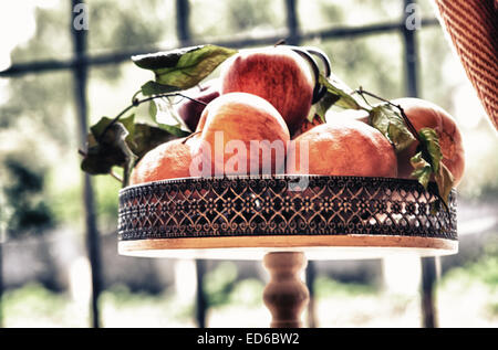 Close up of fresh organic apples with green leaf over copper metal tray Stock Photo