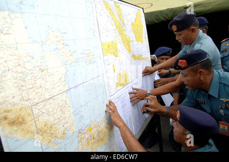 Surabaya, East Java, Indonesia. 29th Dec, 2014. Air Force officials look at a map of the search and rescue for missing of AirAsia flight QZ8501 at Juanda Airport. The missing AirAsia Indonesia flight QZ8501 is likely to be at the bottom of the sea, the head of Indonesia's search-and-rescue agency has said. Bambang Soelistyo said the hypothesis was based on the co-ordinates of the plane when contact with it was lost. The search for the Airbus A320-200, which disappeared with 162 people on board on Sunday on a flight to Singapore, has ended for a second day. The search area will be widened on T Stock Photo