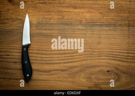 kitchen knife over brown wooden table Stock Photo