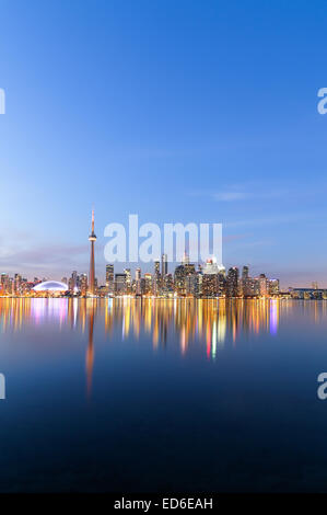 A view of the Toronto Skyline at twilight in the winter showing buildings and reflections in the water Stock Photo