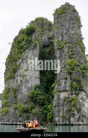 Tourists on wooden row boats and limestone (karst) mound, Vung Vieng fishing village, Ha Long Bay, Bai Tu Long Sector, Vietnam Stock Photo