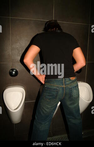 Men standing at mens urinal, toilet, public Stock Photo