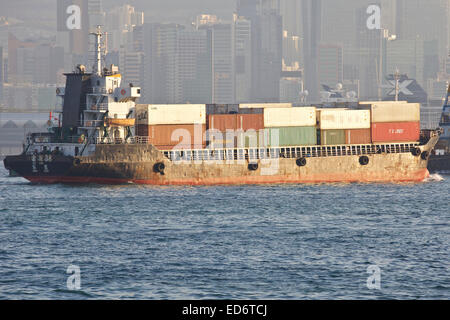 Small Chinese Container Ship Crosses The Busy Shipping Lane In  Kowloon Bay, Hong Kong. Stock Photo